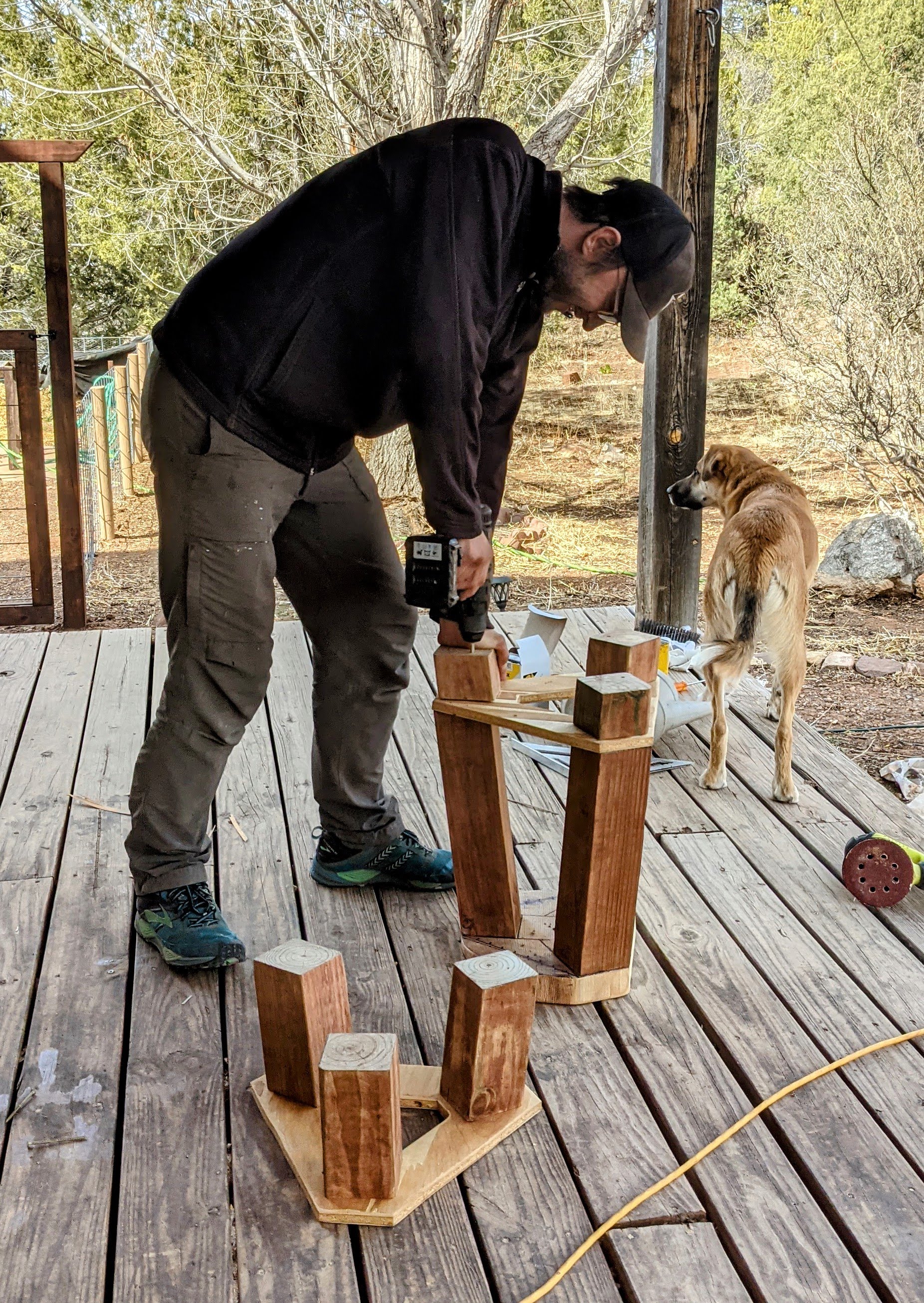 screwing pieces of wood into an upside down stool