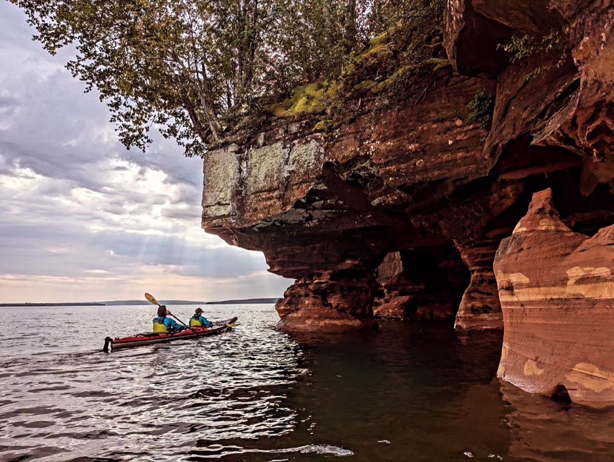 A map comparing train travel times to Bayfield in 1900 with bus travel times in 2024, and photos of kayaking the Apostle Islands